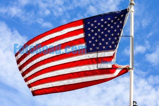 American flag with beautiful blue sky and white clouds
