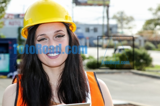 Beautifull young woman construction engineer with a protective y