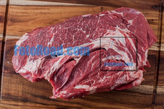 Beef meat on wooden cutting board background