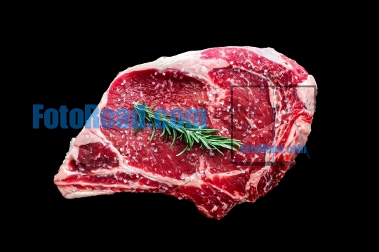 Beef steak bone in with rosemaryand salt isolated on black backg