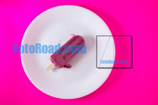Blueberry ice popsicle  on white plate with purple background
