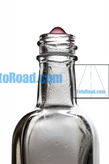 Bottle with red liquid drip on white background