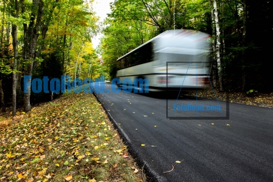 Bus driving thru autumn road
