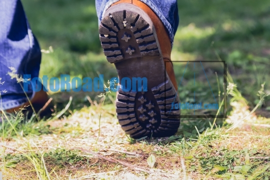 Close up from man in boots walking on grass