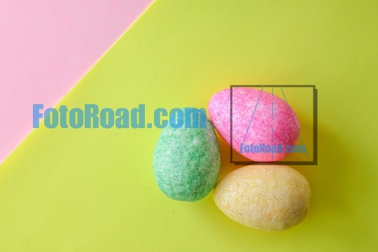 Colorful Easter decorative eggs on yellow and pink colored paper