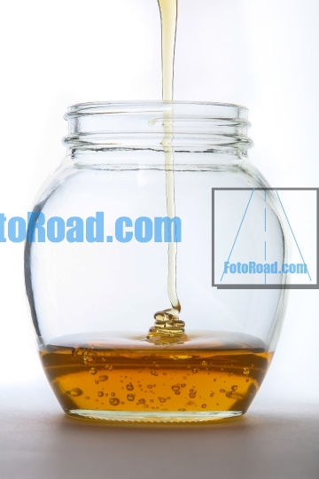 Golden honey stream inside  jar