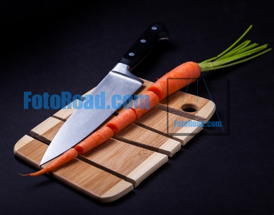 Knife with carrot and wooden cutting board