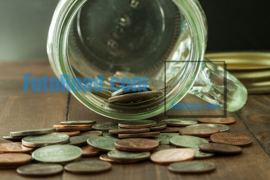 Money in glass jar on wooden table