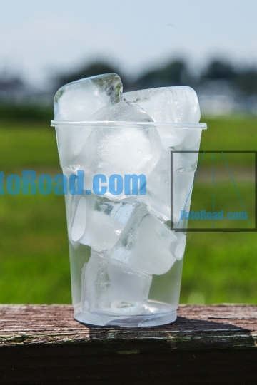 Plastic Cup full of ice melting outdoor
