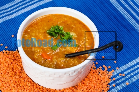 Red lentil organic soup with blue background