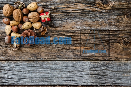 Rustic weathered wooden background for Christmas with nuts and l