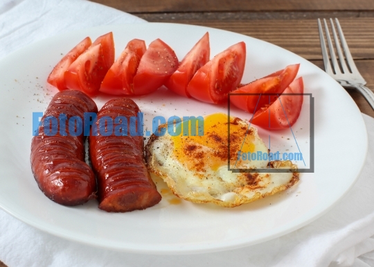 Sausages with tomato and egg on dish