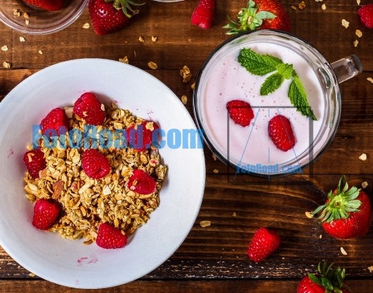 Smoothie with mint on wooden table near granola bowl table top