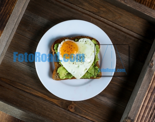 Toast with avocado and egg with heart shape