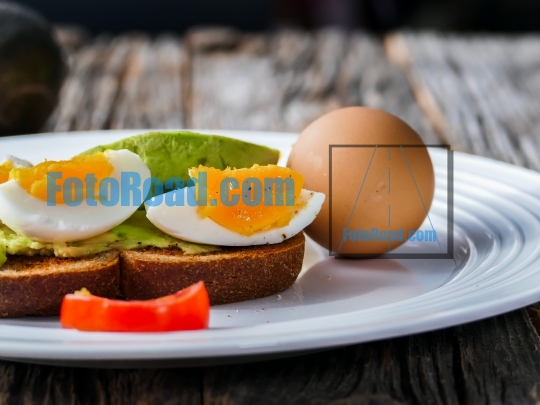 Toast with avocado and eggs on plate