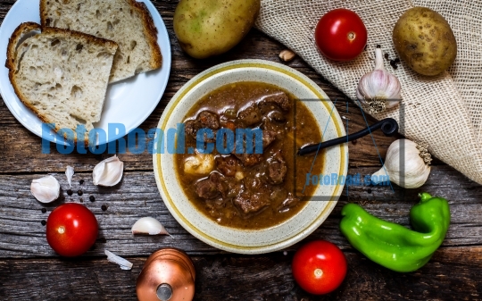 Traditional Slovak beef stew on rustic wooden table