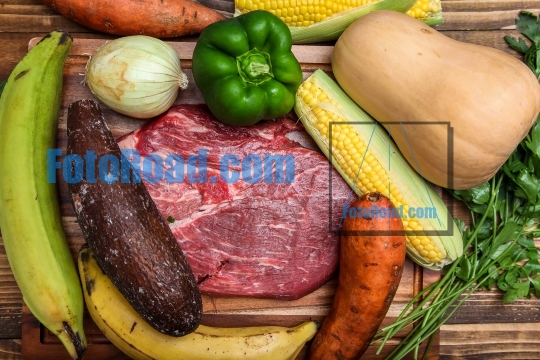 Vegetables and meat on wooden background for sancocho - Puerto R