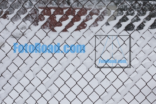 Wired fence background covered with fresh snow 