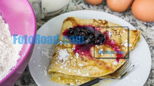 Delicious crepe served with huckleberry spread sauce and powdere