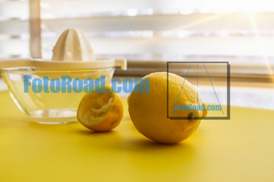 Lemons on yellow table with sun beams ready for squeezing top vi