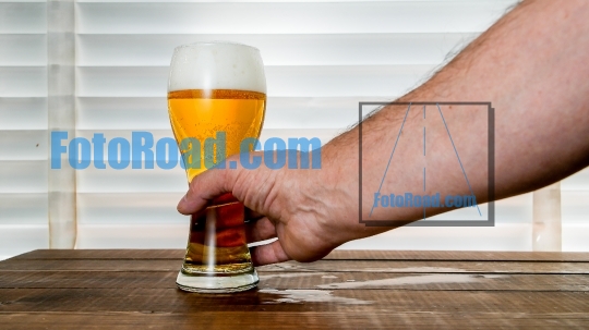 Mans hand is taking beer inside glass on 