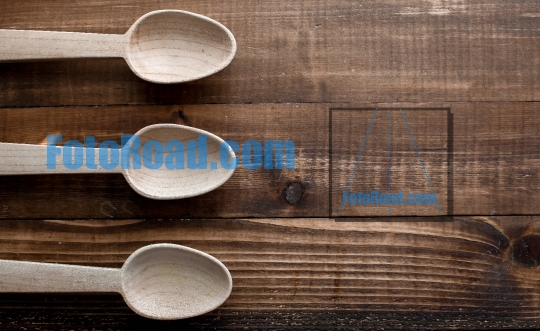 Three empty wooden spoon on wooden table top