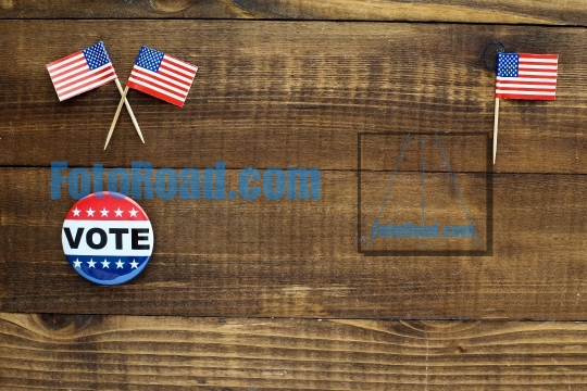 Wooden table top with vote sign and little american flags